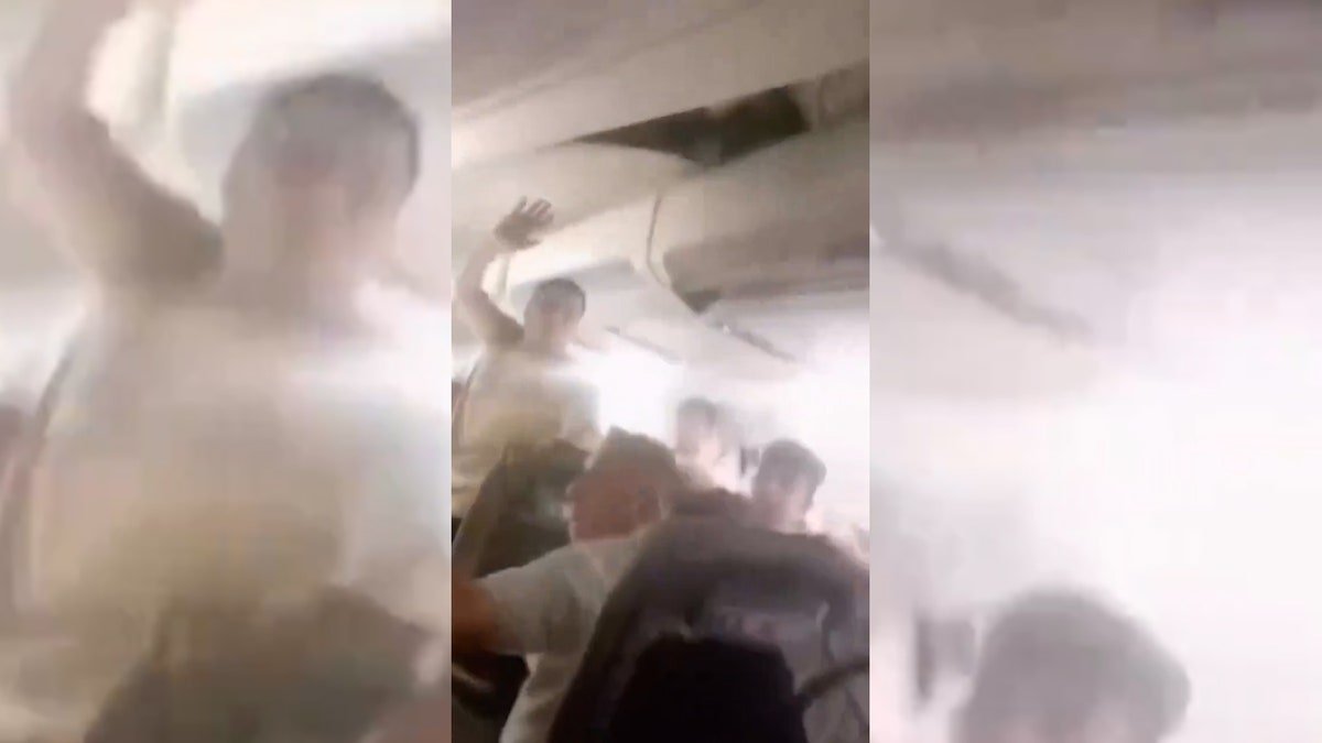 Passengers reacting inside damaged plane cabin.