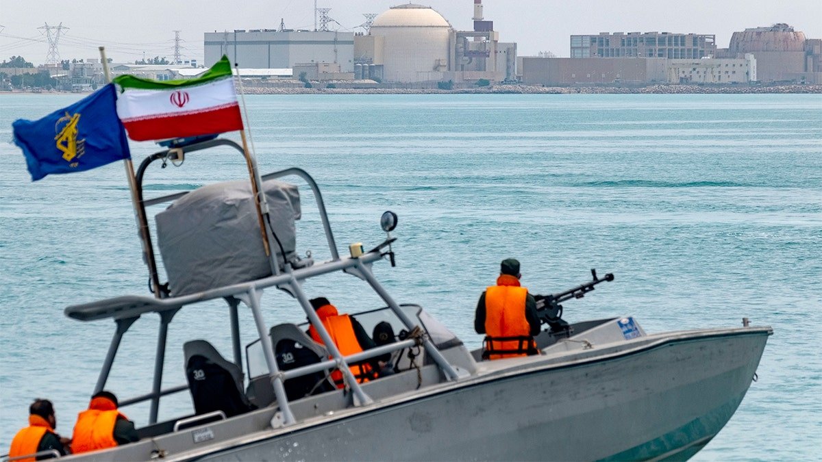 A small military speedboat moves across coastal waters during a naval display.