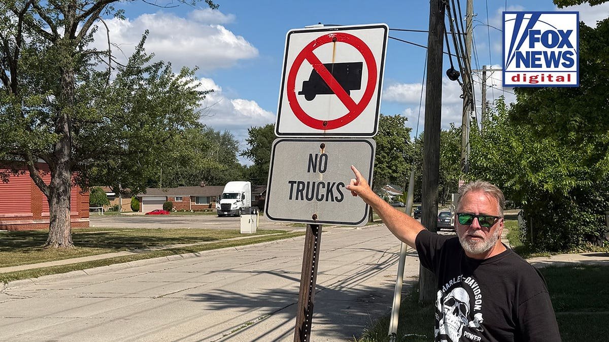 A man pointing at a sign