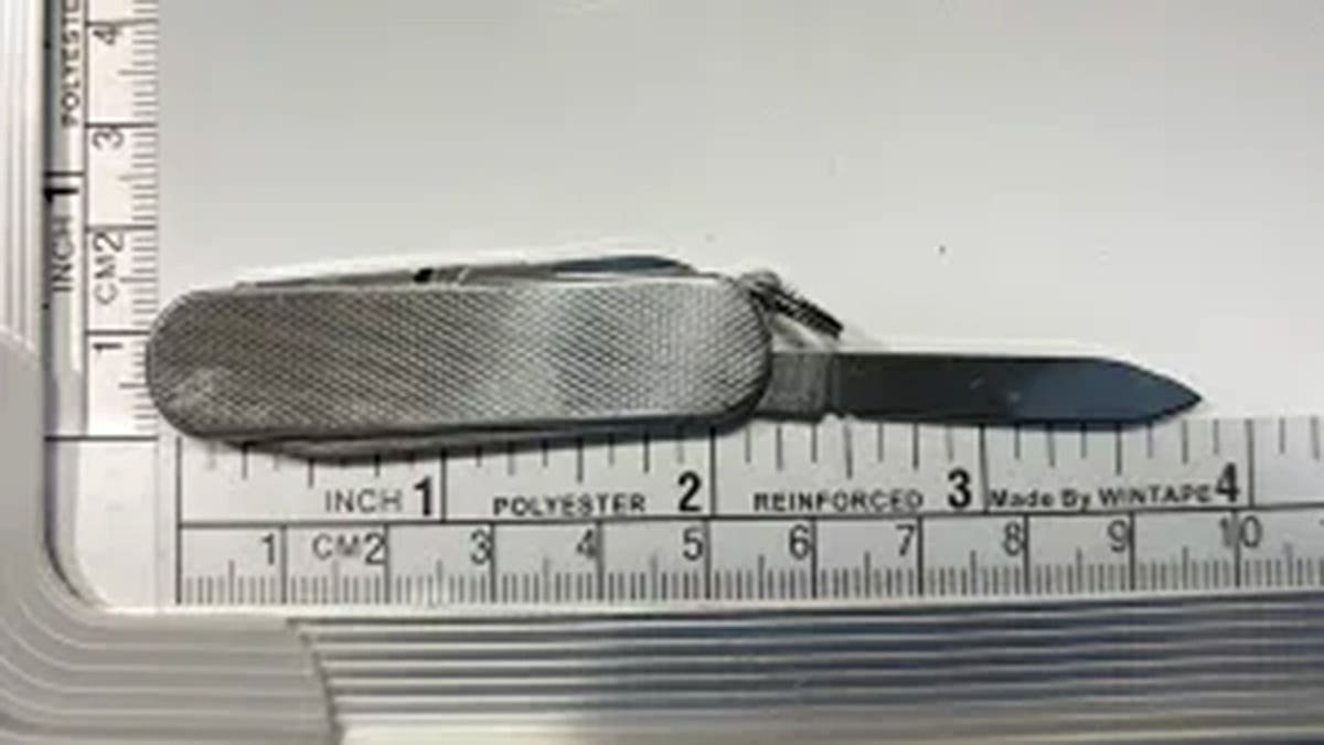 A knife next to a measuring tape.