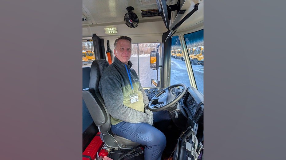 Kurtis Kotes sits in the driver's seat of an East Greenbush school bus.