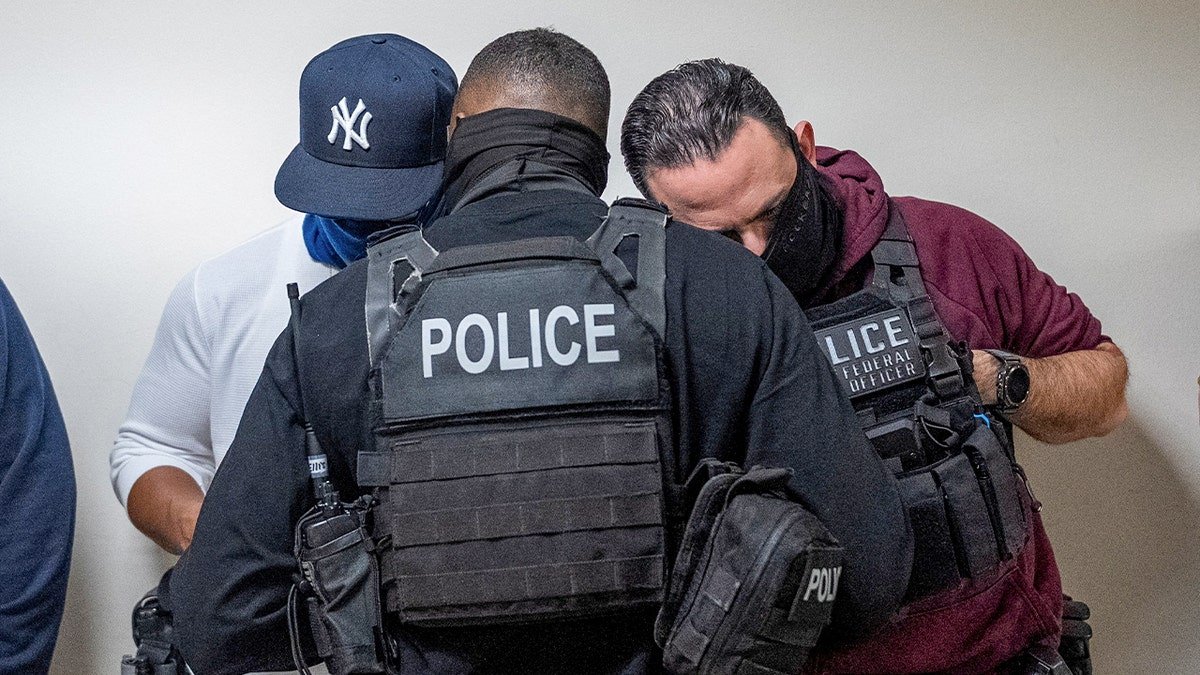 Federal immigration officers consult as they wait for respondents to depart from their hearings to conduct targeted detainments at U.S. immigration court in Manhattan, in New York City, Oct. 24, 2025.