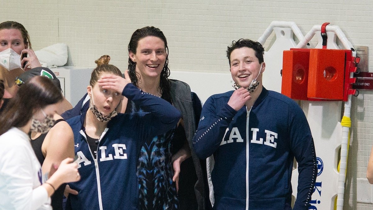 University of Pennsylvania swimmer Lia Thomas (C) smiles with Yale University swimmer Iszac Henig