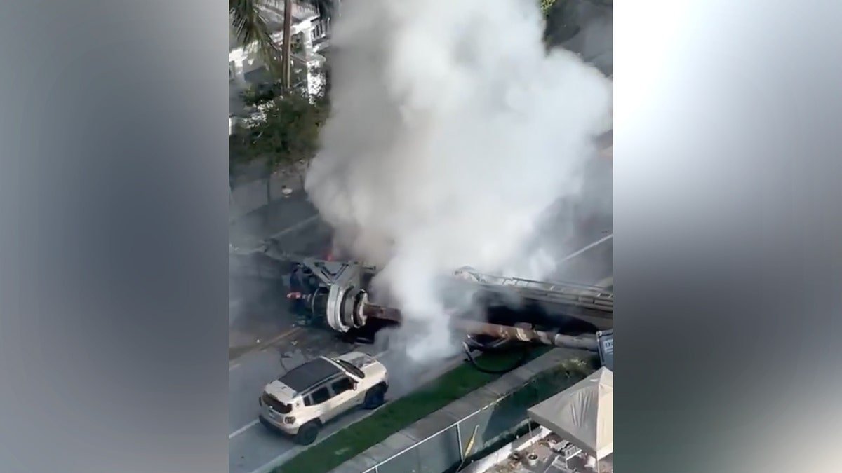 Four people were taken to the hospital Monday after a construction rig toppled onto three vehicles and a construction container in Miami, trapping two workers and igniting a vehicle fire, authorities said.