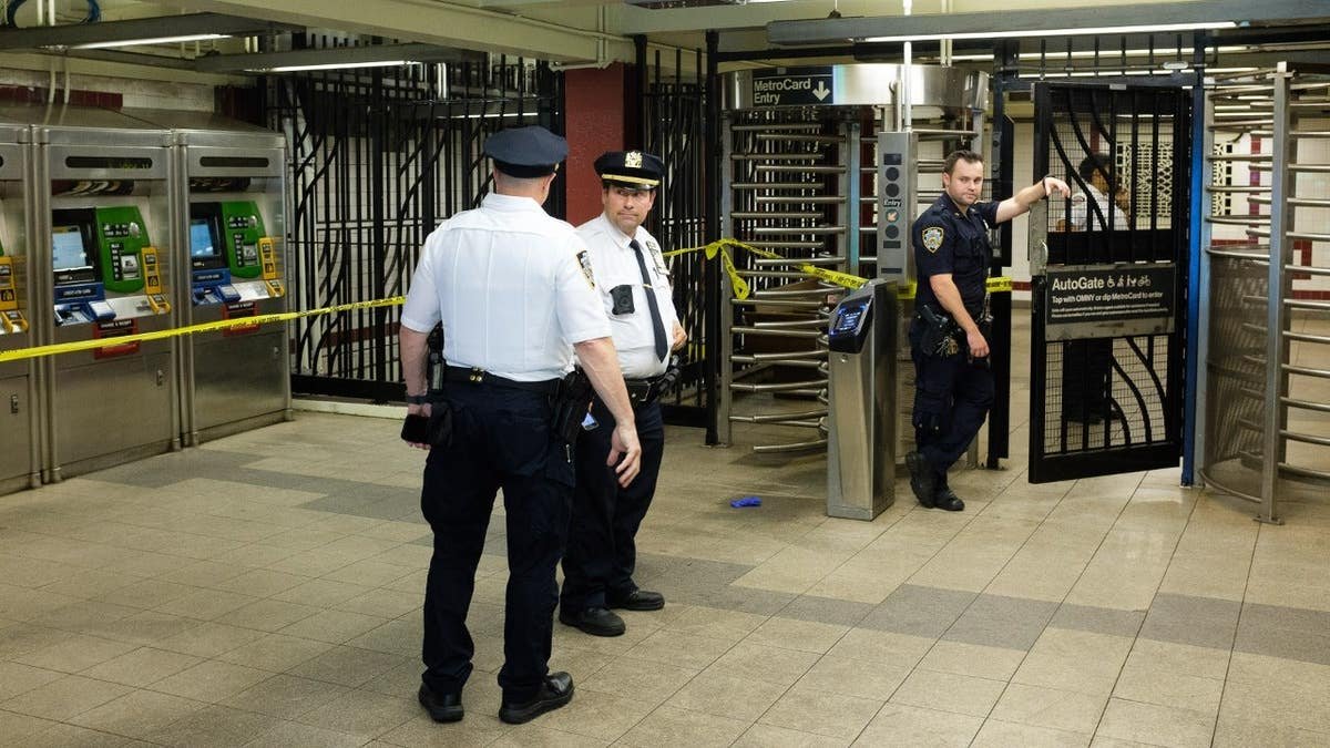 Police walk through Utica Avenue station in Brooklyn