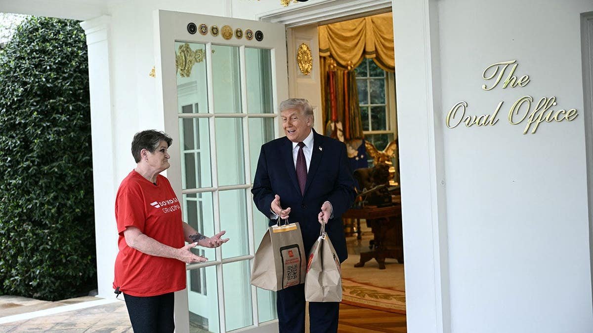 President Donald Trump speaks with a Doordash delivery worker in the Oval Office.