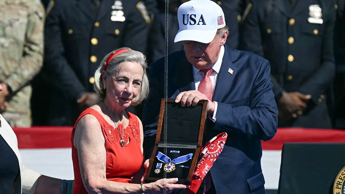 US President Donald Trump presents the Presidential Medal of Freedom to Alison Crowther, on behalf of her son Welles Remy Crowther, a volunteer firefighter who died in the September 11, 2001, attacks during a "Steel Across America" event ahead of the 25th anniversary of the September 11th attacks on the Ellipse near the White House on September 8, 2026 in Washington, DC.