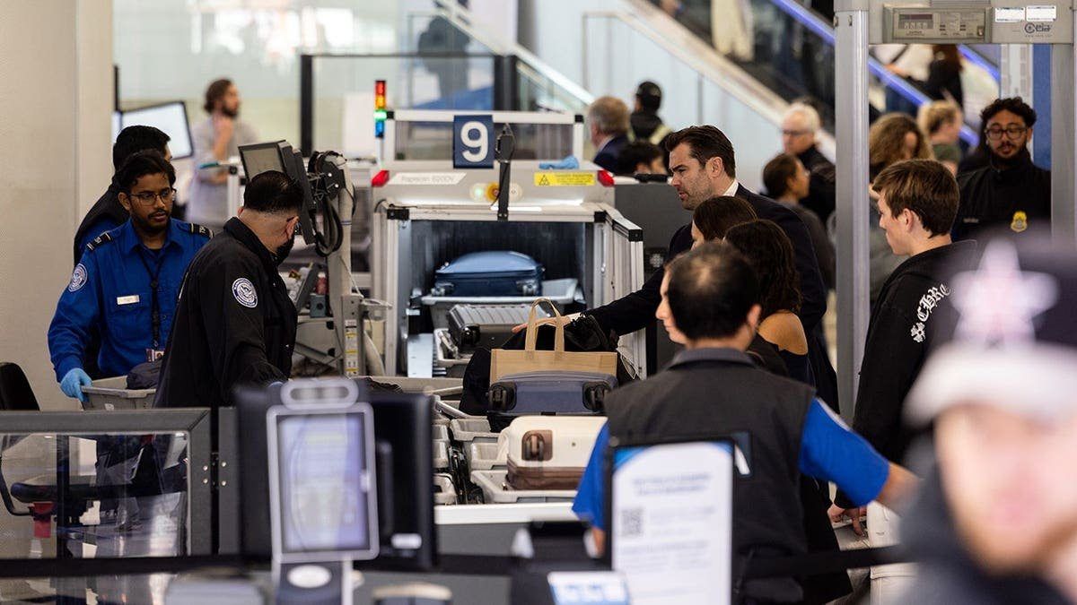 TSA officers screen passengers and check luggage at a security checkpoint in Terminal 7 of Los Angeles International Airport.