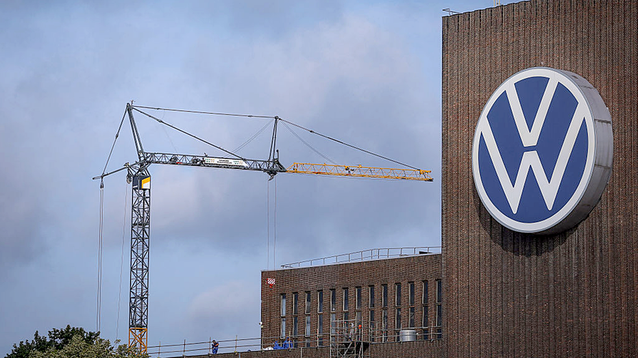 A construction crane is standing next to the VW logo
