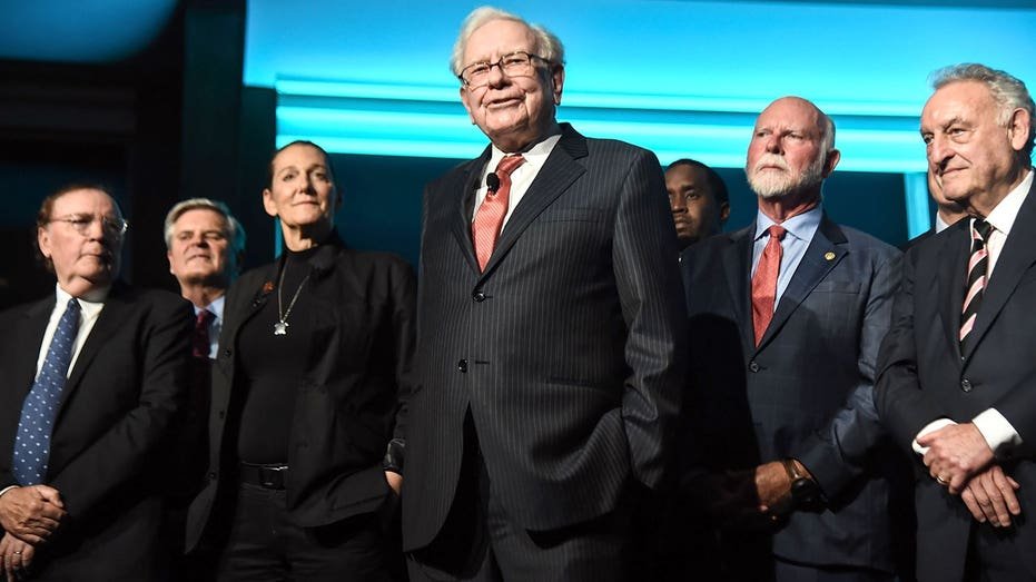Warren Buffett on stage with a group of philanthropists.