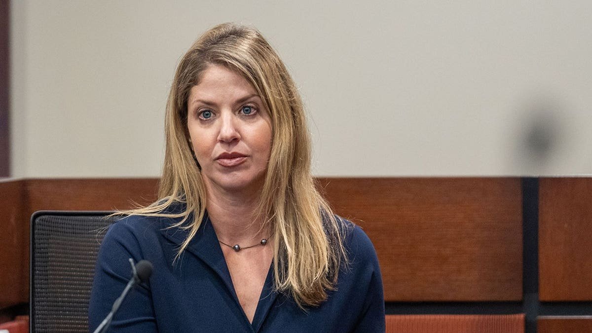 Wendi Adelson watches people leaving a courtroom during a lunch break.